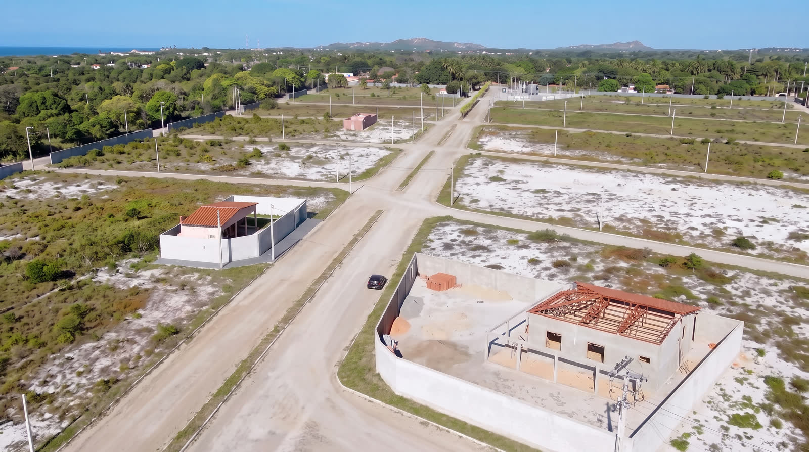 Foto aérea do loteamento entregue, com ruas prontas e casas em construção nos lotes